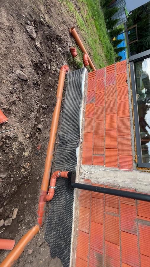 Odwodnienie i rura kanalizacyjna poprowadzona przy fundamencie